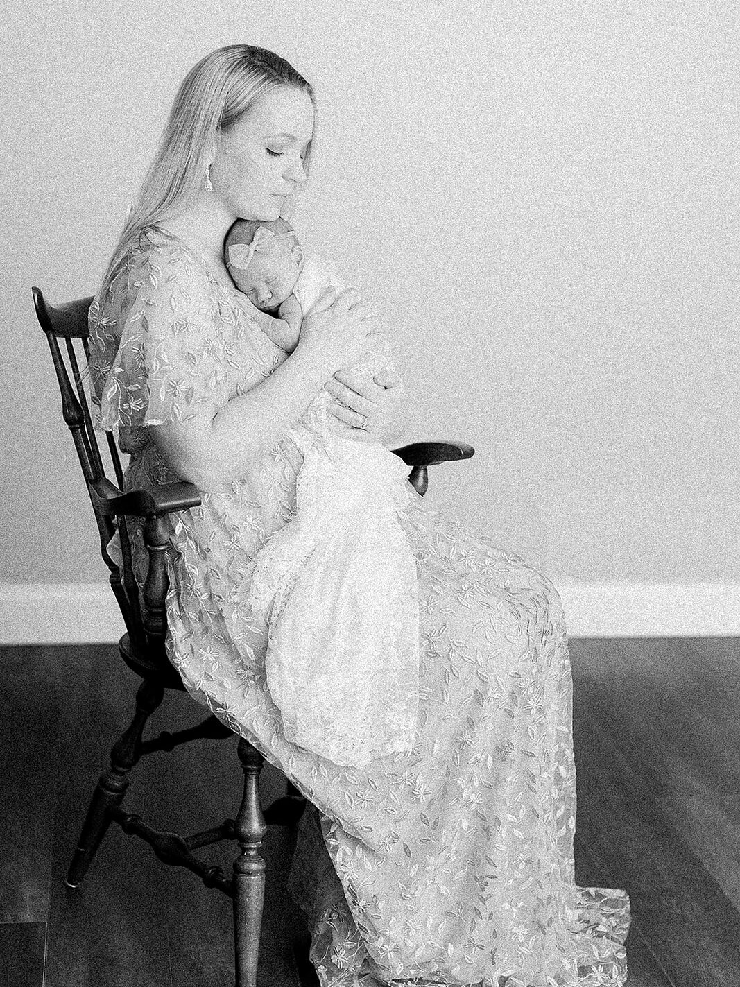 Natural candid of a mother soothing her newborn in her arms, capturing authentic postpartum connection.